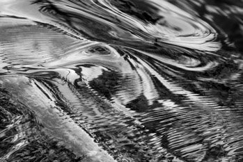 "Surface Tension" by Nat Coalson. Close up, black and white photograph of shallow water flowing over a rocky creek bed in Plitvice Lakes National Park, Croatia shows dramatic patterns and textures created by ripples both large and small. Prints available in any size and on any material. For details click the Purchase link above.